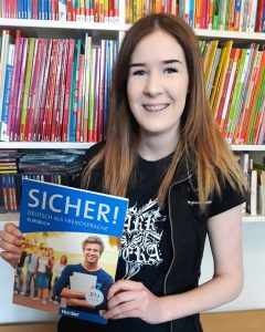Student holding Sicher B1 German textbook